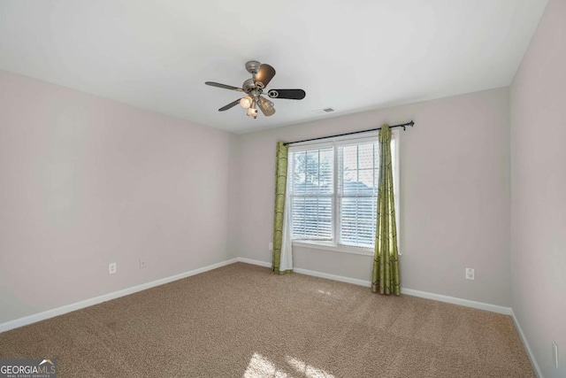 spare room featuring ceiling fan and carpet floors