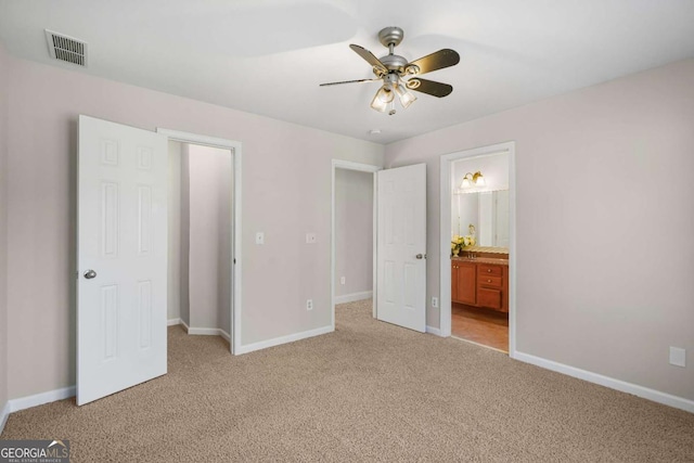 unfurnished bedroom with ensuite bathroom, ceiling fan, and light colored carpet