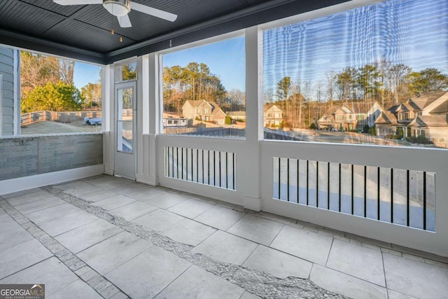 unfurnished sunroom featuring ceiling fan