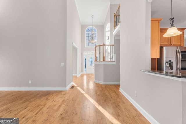 hallway featuring light hardwood / wood-style floors and an inviting chandelier