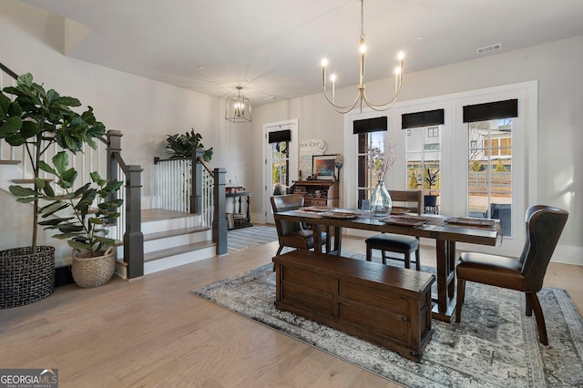 dining area featuring light hardwood / wood-style flooring and a chandelier