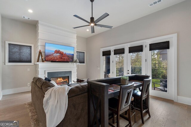 living room with ceiling fan, french doors, and light hardwood / wood-style floors