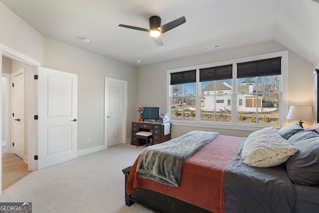 bedroom with ceiling fan, light colored carpet, and vaulted ceiling