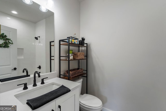 bathroom featuring walk in shower, vanity, and toilet