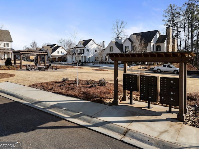 view of home's community with a pergola and mail boxes