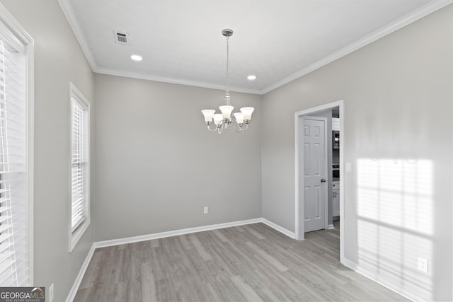 spare room with ornamental molding, light hardwood / wood-style flooring, and a notable chandelier