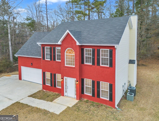 view of front of property featuring a front yard, cooling unit, and a garage