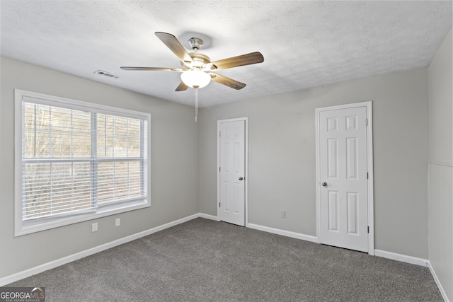 unfurnished bedroom with ceiling fan, carpet, and a textured ceiling