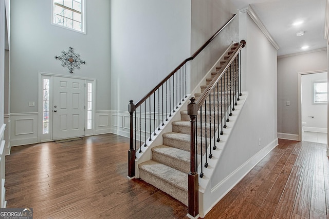 entryway featuring crown molding and dark wood-type flooring