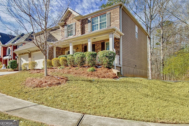 view of front of property with a porch, a garage, and a front yard