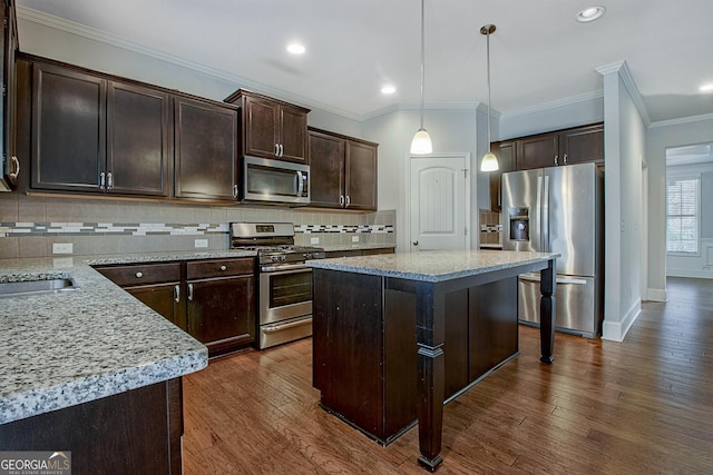 kitchen with pendant lighting, a center island, tasteful backsplash, dark brown cabinetry, and stainless steel appliances