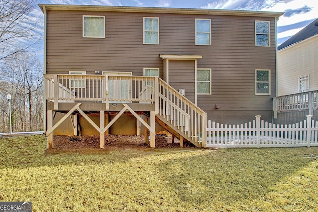 rear view of property featuring a lawn and a wooden deck