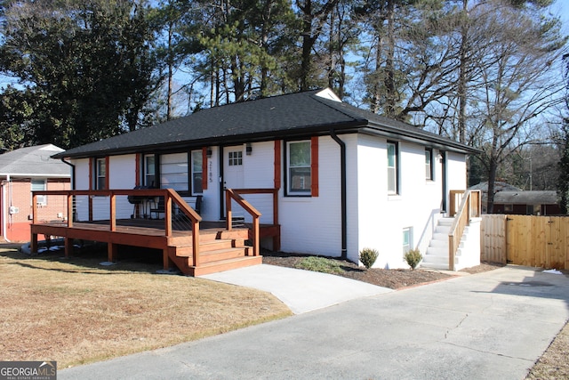 view of front of house featuring a wooden deck and a front lawn