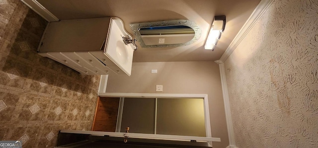 bathroom with crown molding and tile walls