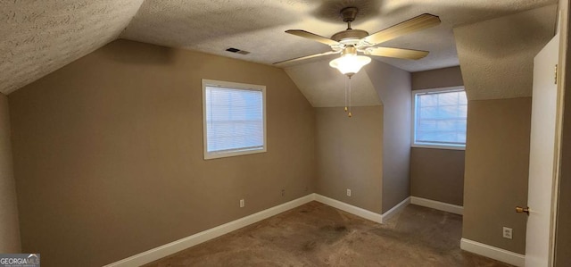 bonus room featuring vaulted ceiling, ceiling fan, carpet floors, and a textured ceiling