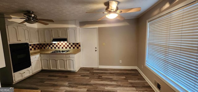 kitchen with tasteful backsplash, a textured ceiling, stainless steel gas cooktop, dark hardwood / wood-style floors, and oven