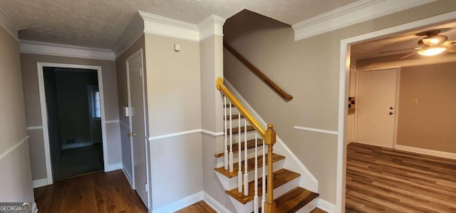 stairway featuring ceiling fan, hardwood / wood-style floors, crown molding, and a textured ceiling