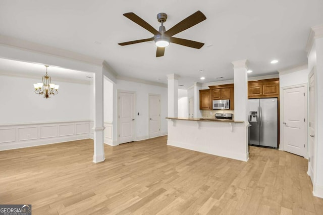 kitchen with a breakfast bar, ornamental molding, appliances with stainless steel finishes, light hardwood / wood-style floors, and kitchen peninsula