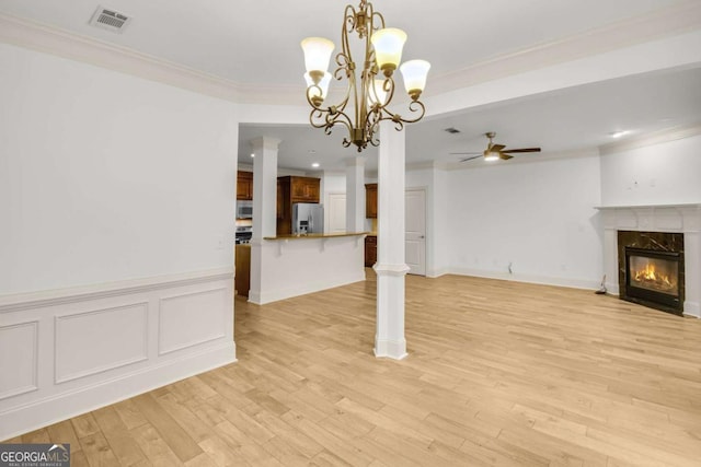 unfurnished living room with a premium fireplace, crown molding, light hardwood / wood-style floors, and ceiling fan with notable chandelier