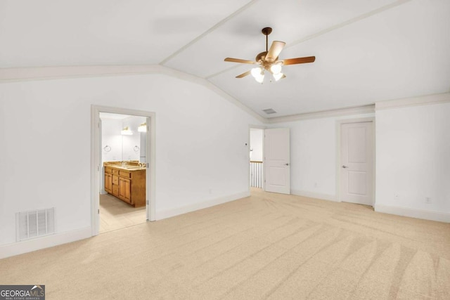 unfurnished bedroom featuring light carpet, ensuite bathroom, ornamental molding, ceiling fan, and lofted ceiling