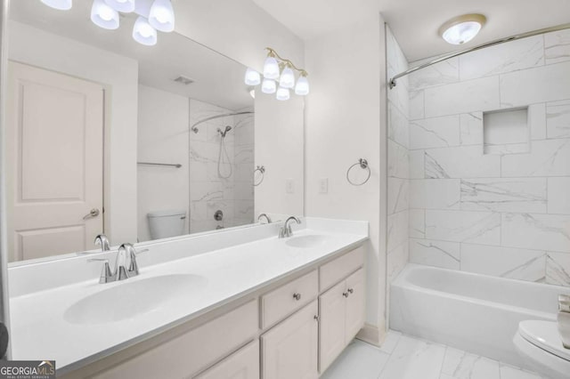 full bathroom featuring vanity, tiled shower / bath combo, and toilet