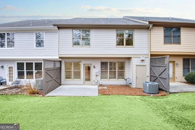 back of house featuring a patio, central AC unit, and a lawn