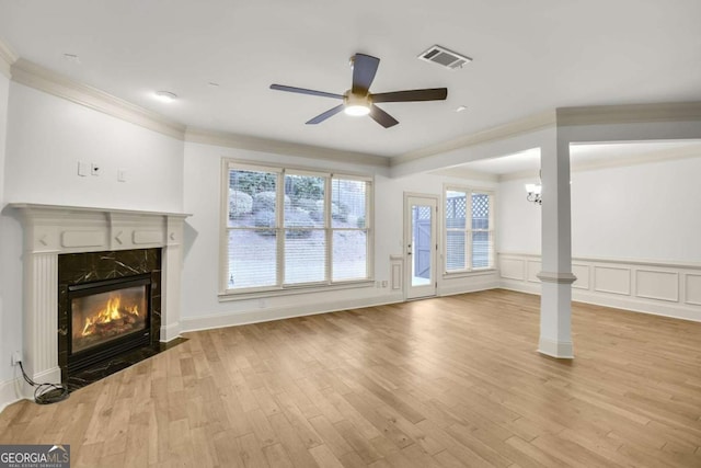 unfurnished living room featuring ceiling fan with notable chandelier, light hardwood / wood-style floors, and a fireplace