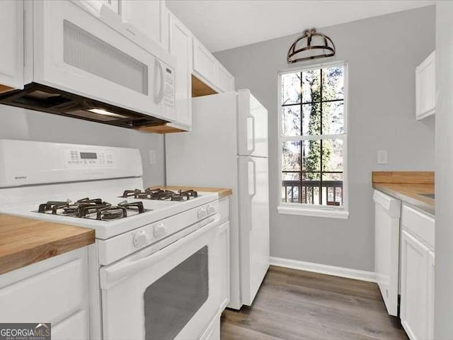 kitchen with butcher block countertops, white cabinets, dark hardwood / wood-style floors, and white appliances