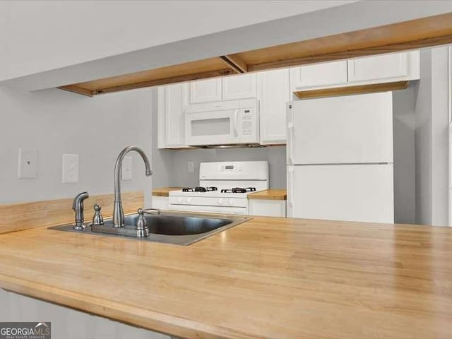 kitchen with white cabinetry, sink, and white appliances