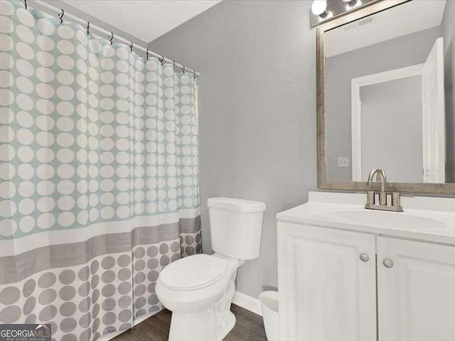 bathroom with hardwood / wood-style floors, vanity, and toilet