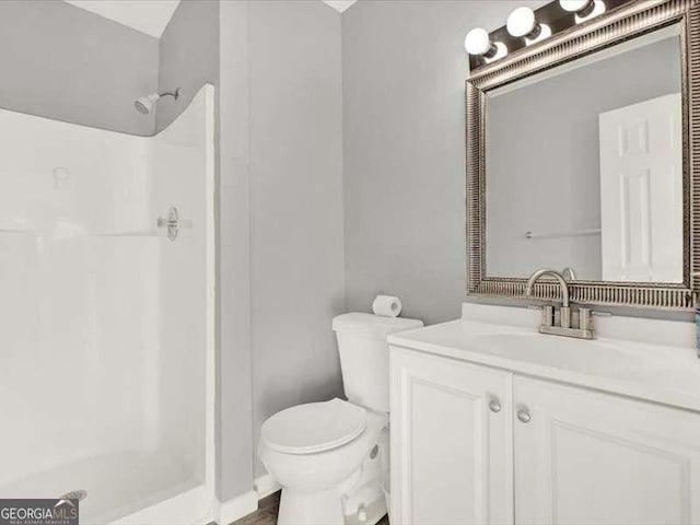 bathroom with vanity, toilet, and walk in shower