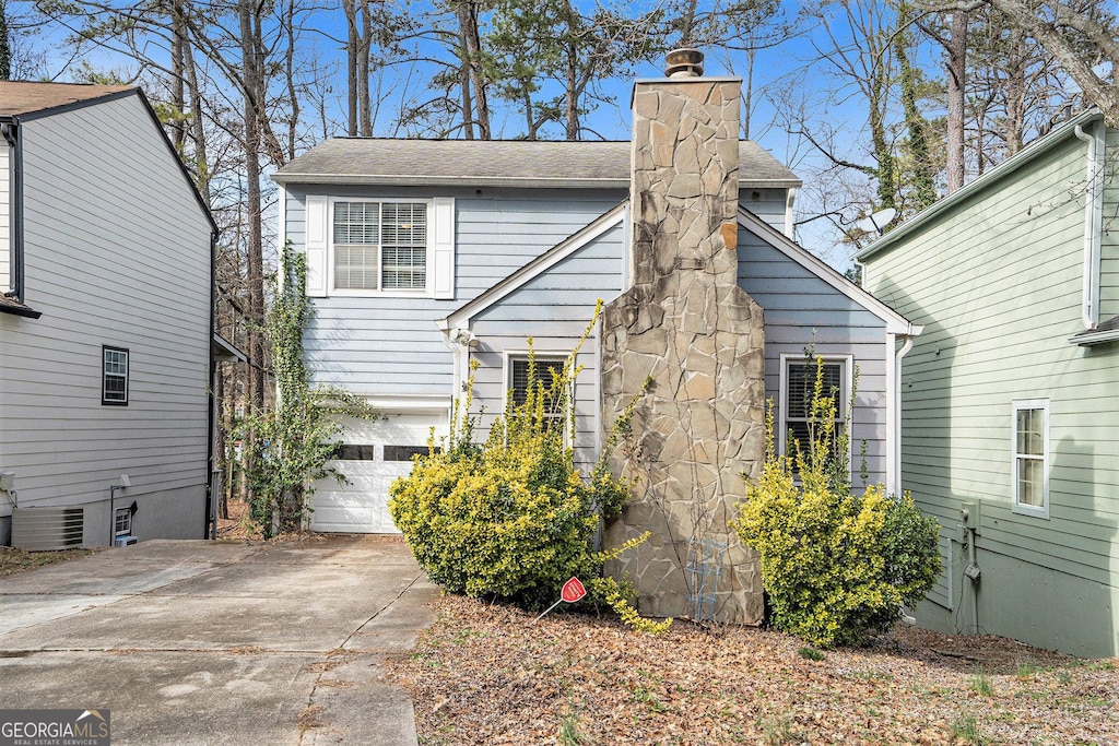 view of front of house with a garage and central AC unit