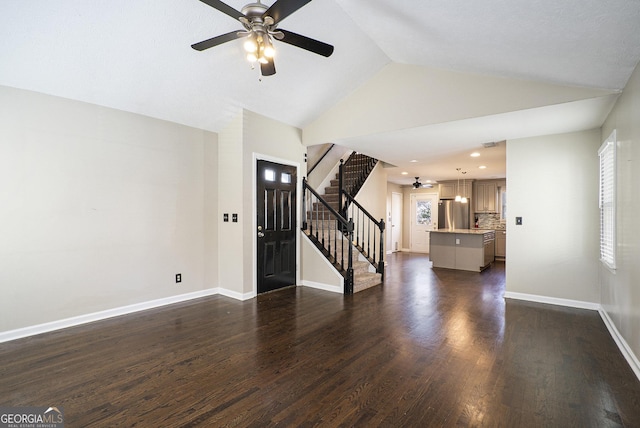 unfurnished living room featuring lofted ceiling, plenty of natural light, dark hardwood / wood-style floors, and ceiling fan