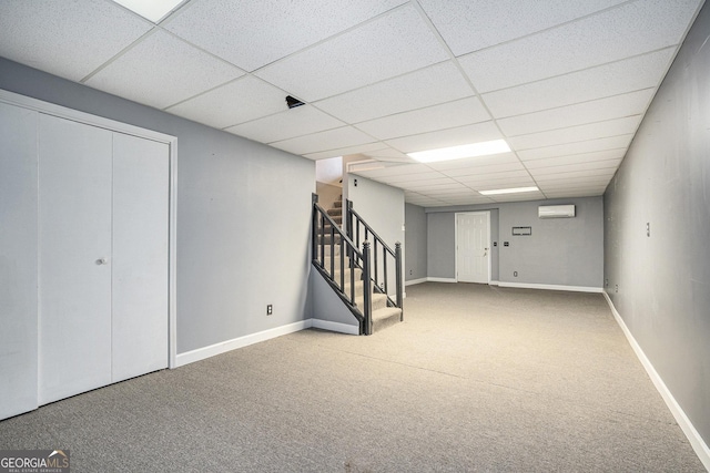 basement with a paneled ceiling and carpet