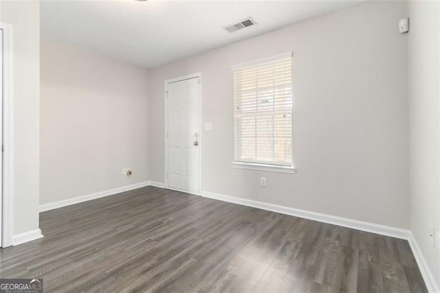 unfurnished room with dark hardwood / wood-style flooring