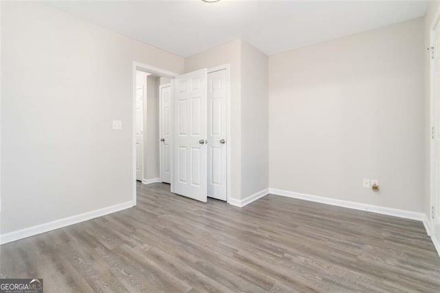 unfurnished bedroom featuring a closet and hardwood / wood-style flooring