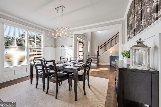 dining room with ornamental molding, dark hardwood / wood-style flooring, and a notable chandelier