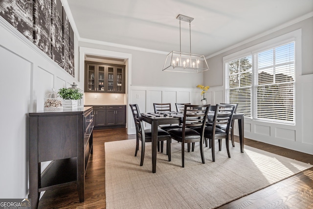 dining room with ornamental molding, a notable chandelier, and dark hardwood / wood-style floors