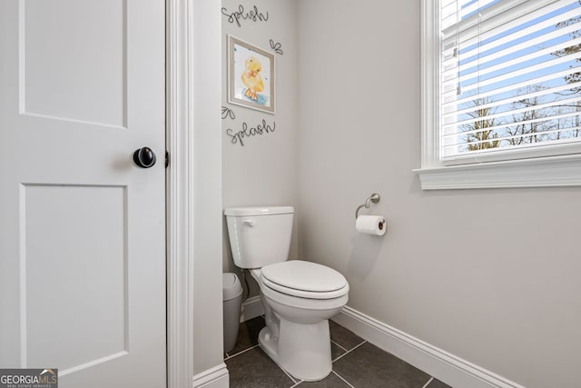 bathroom featuring toilet, tile patterned flooring, and a healthy amount of sunlight