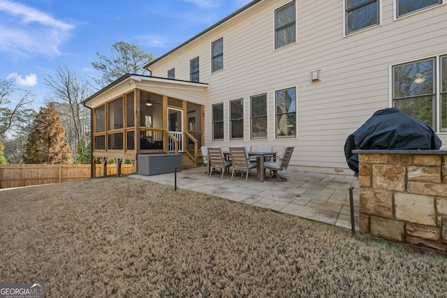 back of property with a patio area, a lawn, and a sunroom