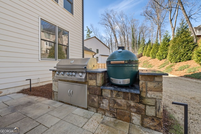 view of patio / terrace featuring exterior kitchen and a grill