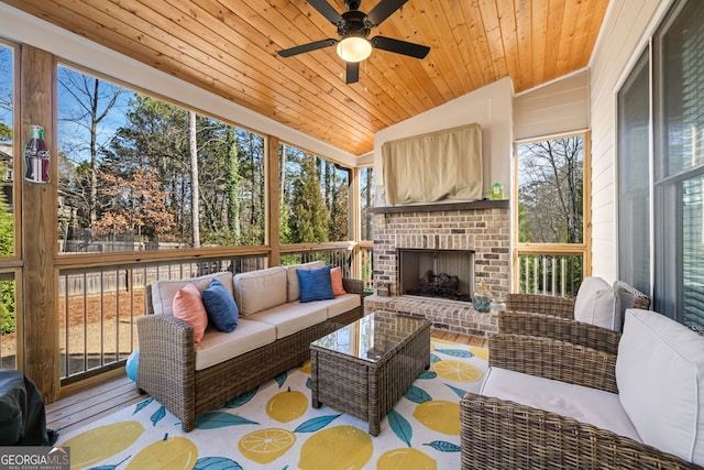 sunroom / solarium with ceiling fan, wood ceiling, vaulted ceiling, and an outdoor brick fireplace