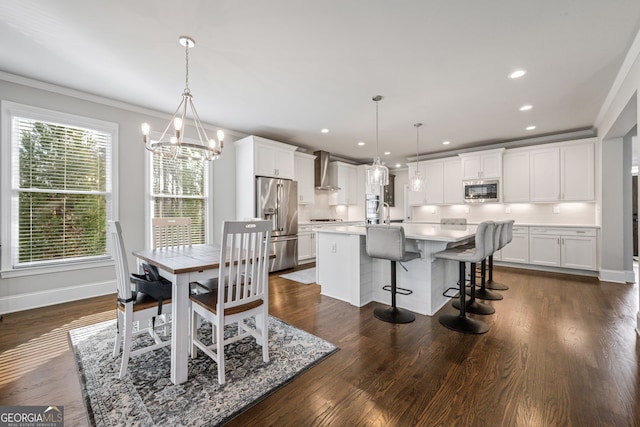 dining room featuring an inviting chandelier, ornamental molding, dark hardwood / wood-style flooring, and sink