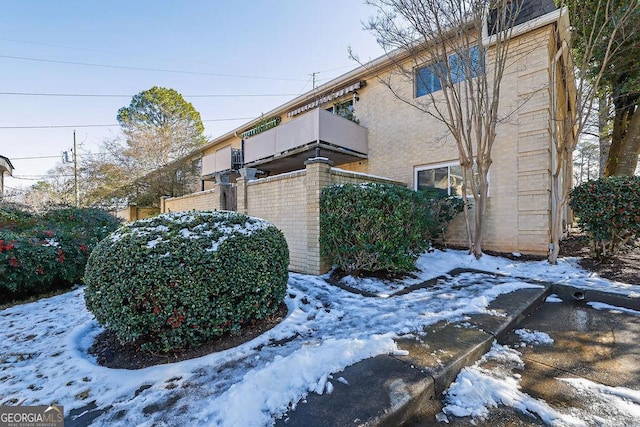 view of snow covered exterior featuring a balcony