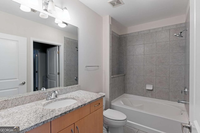 full bathroom featuring tile patterned flooring, vanity, toilet, and tiled shower / bath