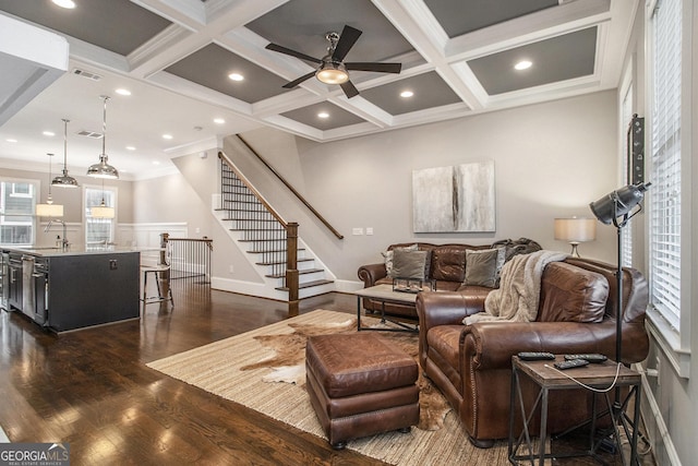 living room featuring sink, crown molding, coffered ceiling, dark hardwood / wood-style flooring, and beamed ceiling