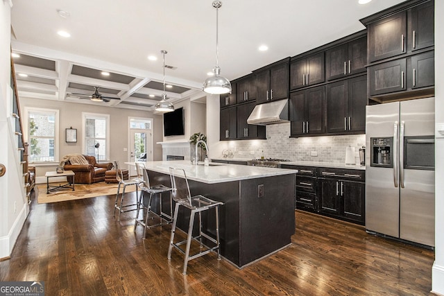 kitchen featuring pendant lighting, a kitchen island with sink, stainless steel appliances, coffered ceiling, and beamed ceiling