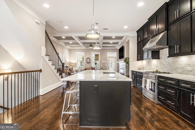 kitchen featuring coffered ceiling, sink, beamed ceiling, a center island with sink, and high end stainless steel range oven