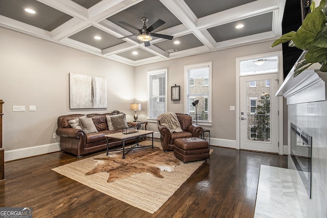 living room featuring dark wood-type flooring, ceiling fan, coffered ceiling, and beamed ceiling