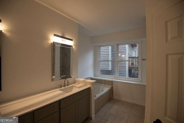 bathroom featuring tile patterned flooring, vanity, and tiled tub